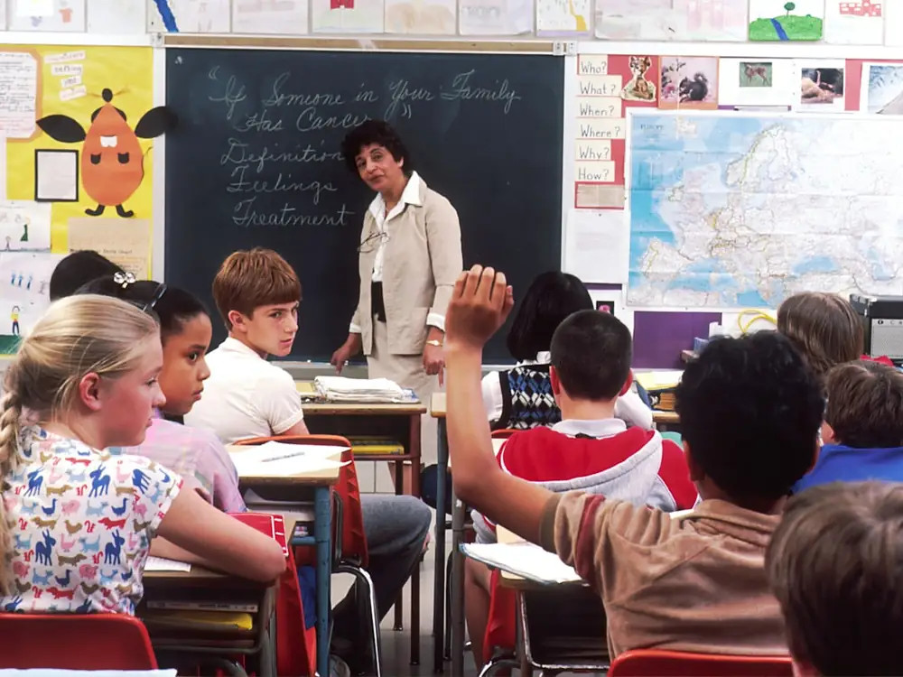 Teacher providing personalised guidance to students in a classroom